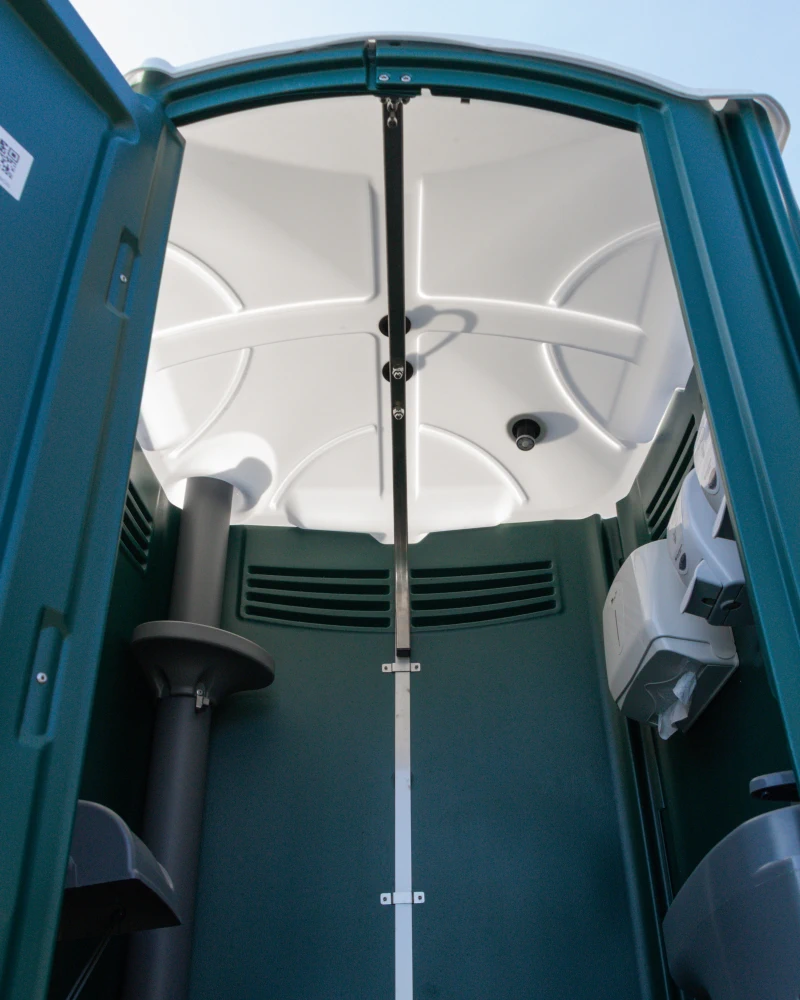 Geöffnetes Kran-WC mit geteilter Tür: Blick in den Innenraum mit WC-Becken, Ventilation und Papierspender.